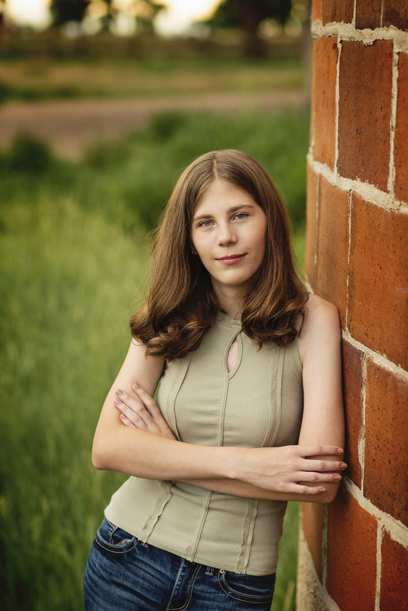 High School Senior Pictures Girl Leaning Against a Red Silo at 17 Mile Farm Park in Centennial, Colorado