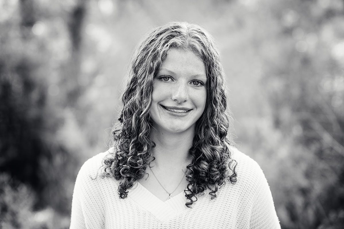 black and white headshot of a senior girl with curly hair; Parker senior pictures in Colorado