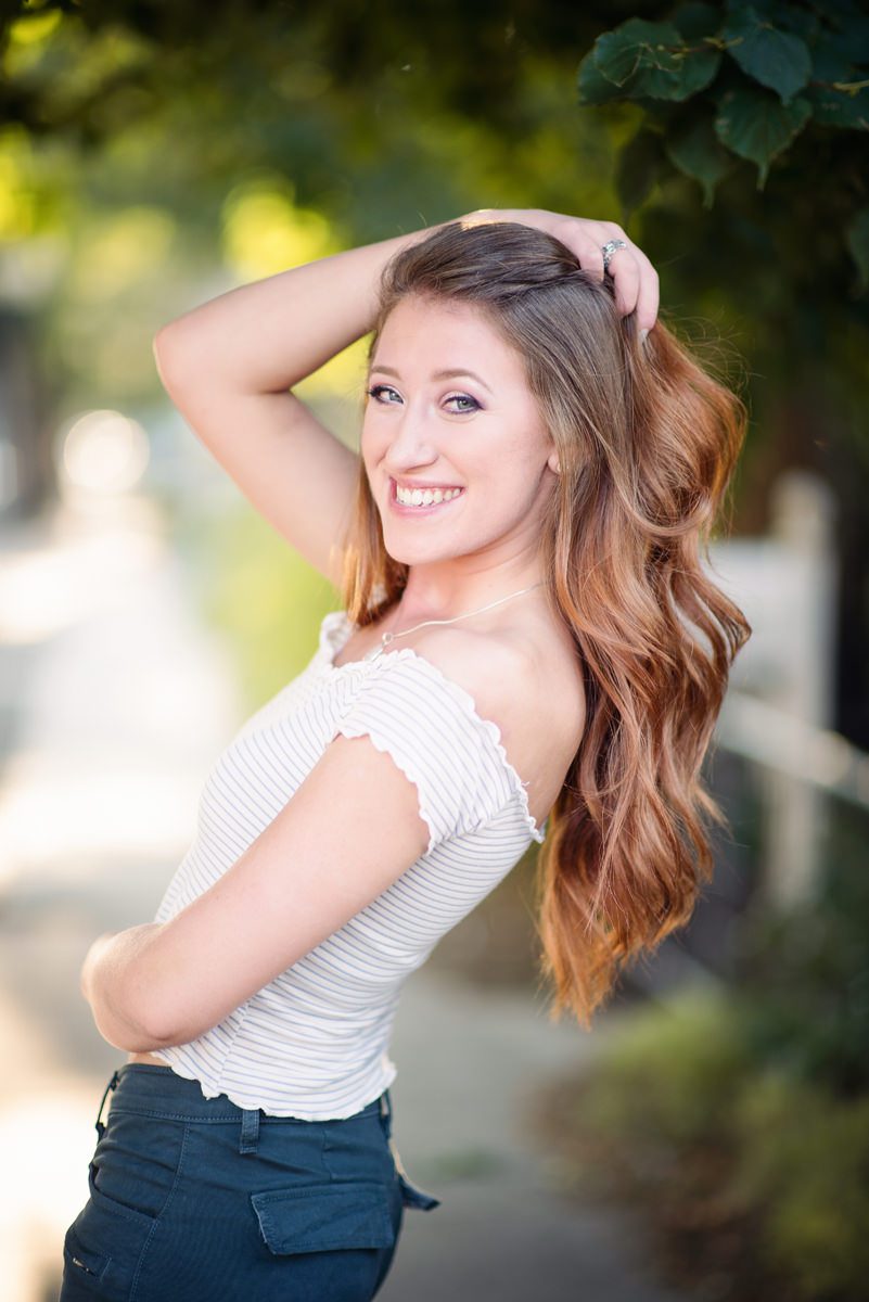 Parker senior picture of a girl holding her hair smiling at camera in a natural pose