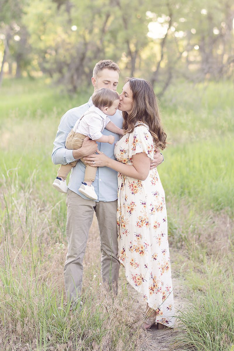 Family kissing toddler outdoor pictures taken by Parker family photographer, Jamie Herrera