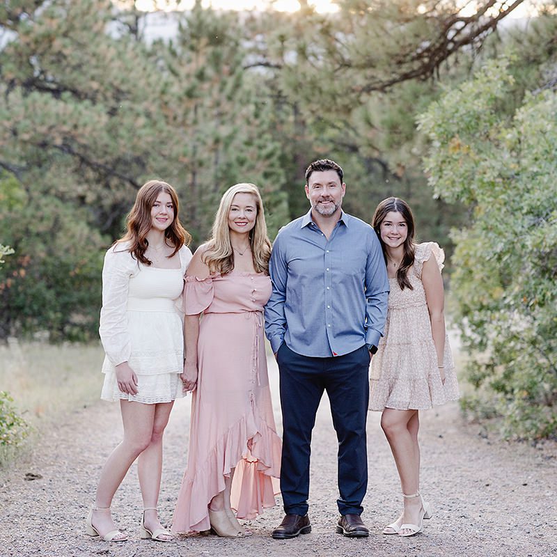 Jamie Herrera Photography review by a family dressed up and smiling on a path surrounded by trees