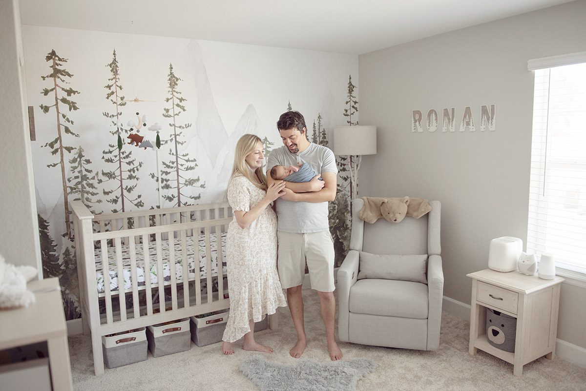 woodlands themed nursery professional pictures of parents holding baby in nursery