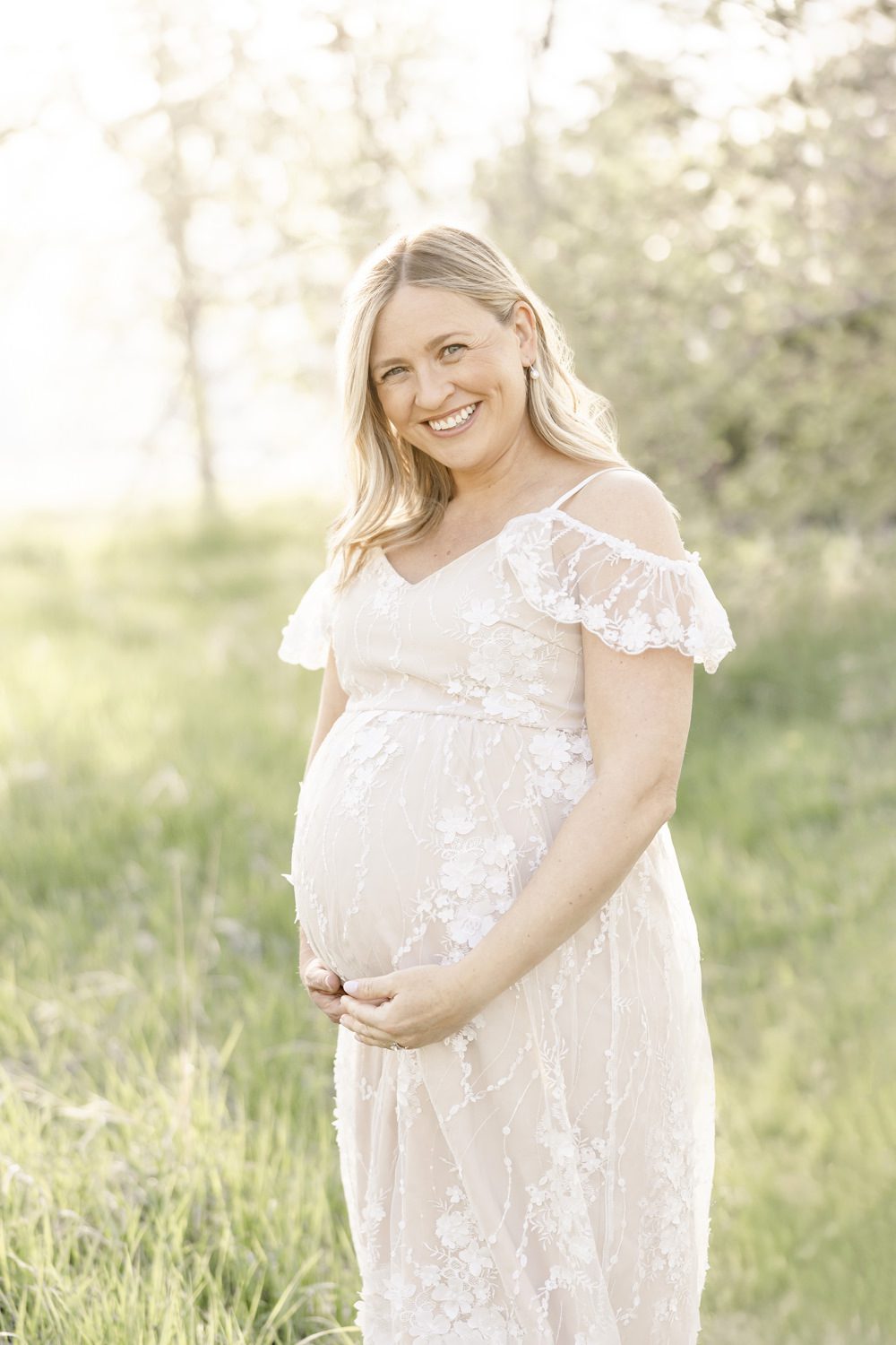 Pregnant mom wearing lace, smiling looking at the camera