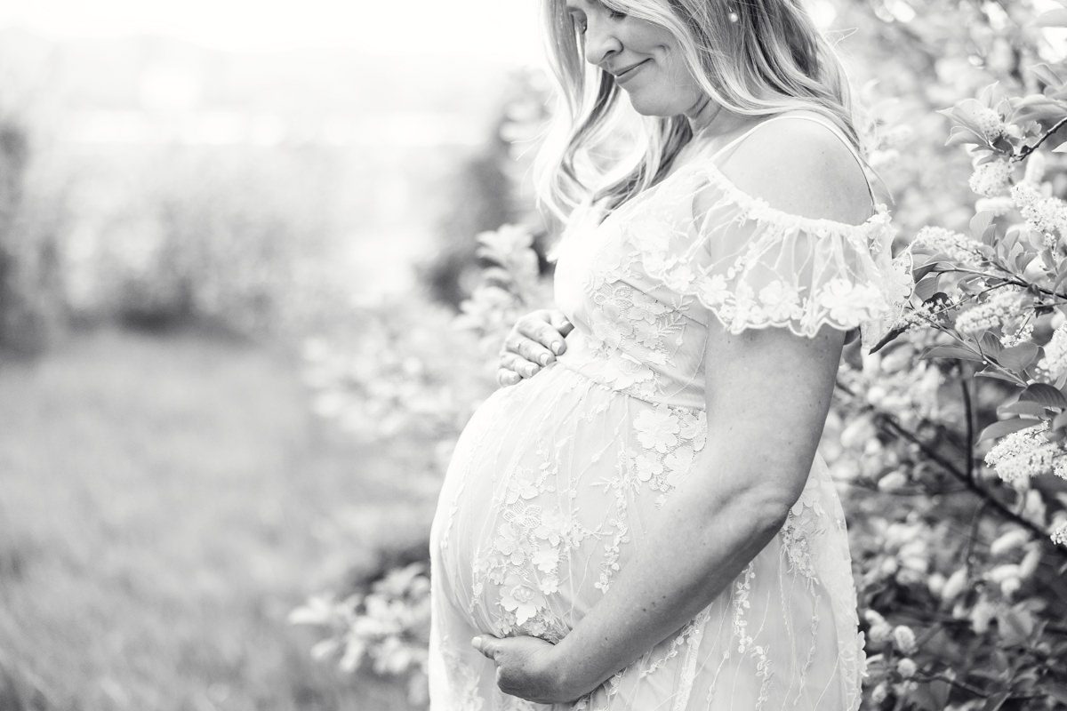 Pregnant mom wearing lace outdoor with spring blossoms