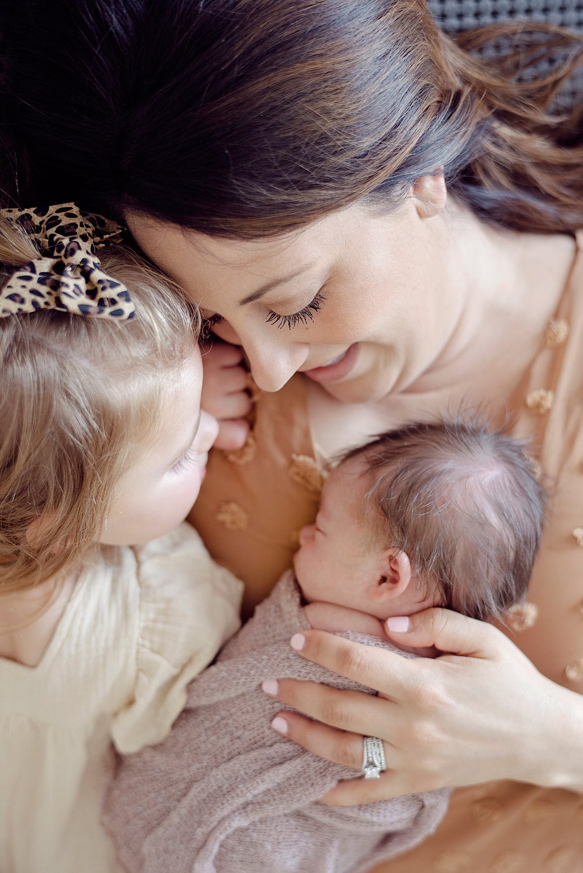 mom holding new baby with sister photo taken by an Aurora Colorado newborn photographer